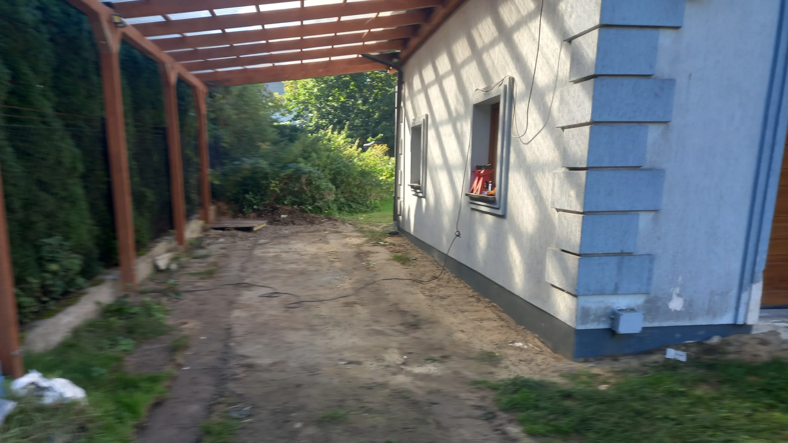 Stan terenu pod wiatą garażową przed rozpoczęciem prac brukarskich Nieutwardzony teren pod wiatą garażową przed rozpoczęciem prac związanych z układaniem kostki brukowej