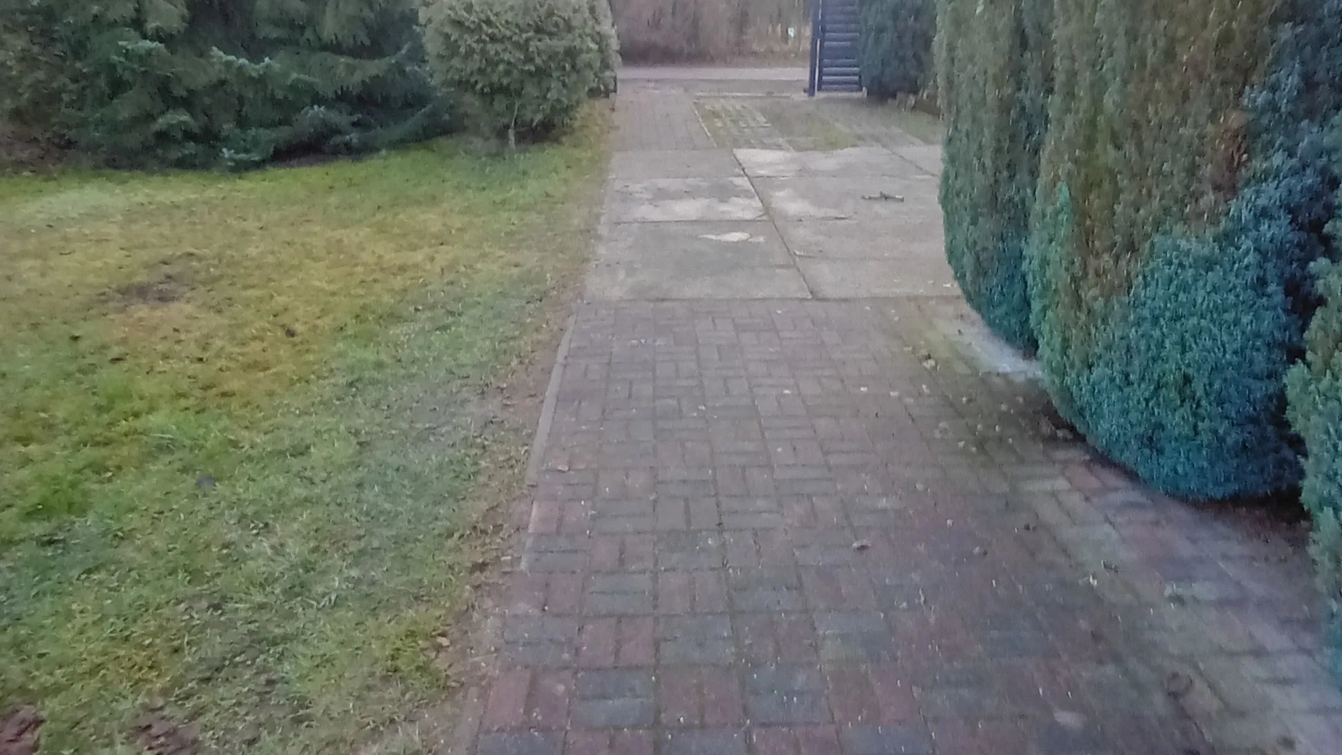 Zdegradowany podjazd i obrzeże w stanie pierwotnym przed wykonaniem nowej opaski oraz instalacji oświetlenia
