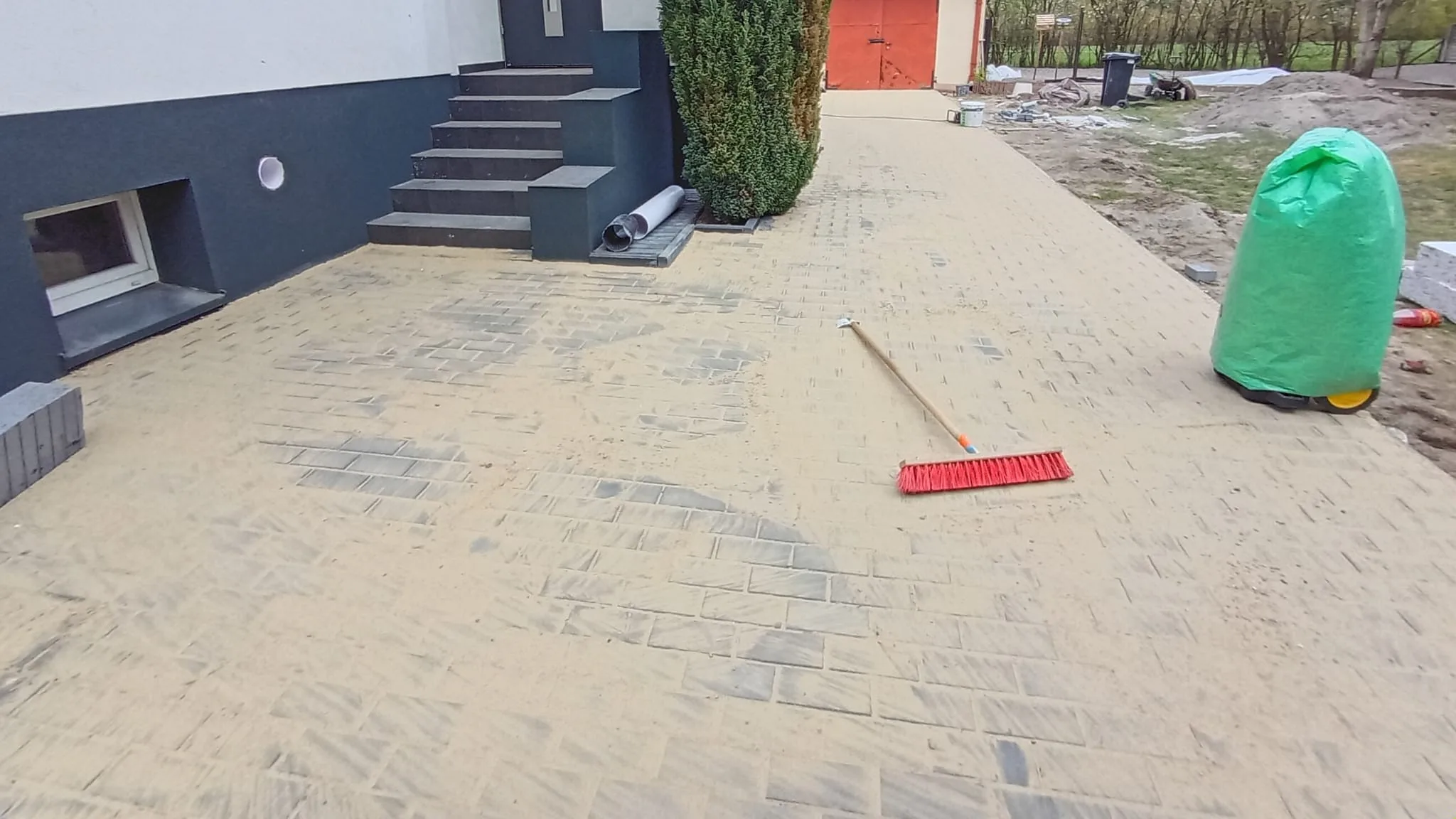 Świeżo wymieniona nawierzchnia z kostki brukowej zafugowana sianym piaskiem na nowym podjeździe
