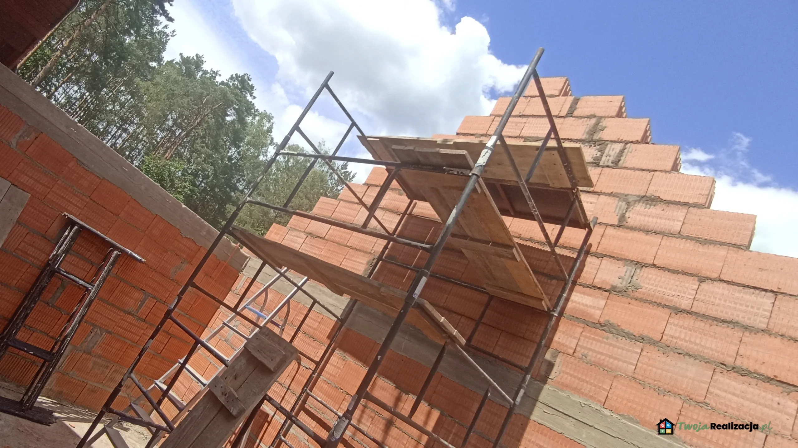 Nowa dobudówka z łazienką i garderobą połączona z istniejącym budynkiem, widoczne prace wykończeniowe
